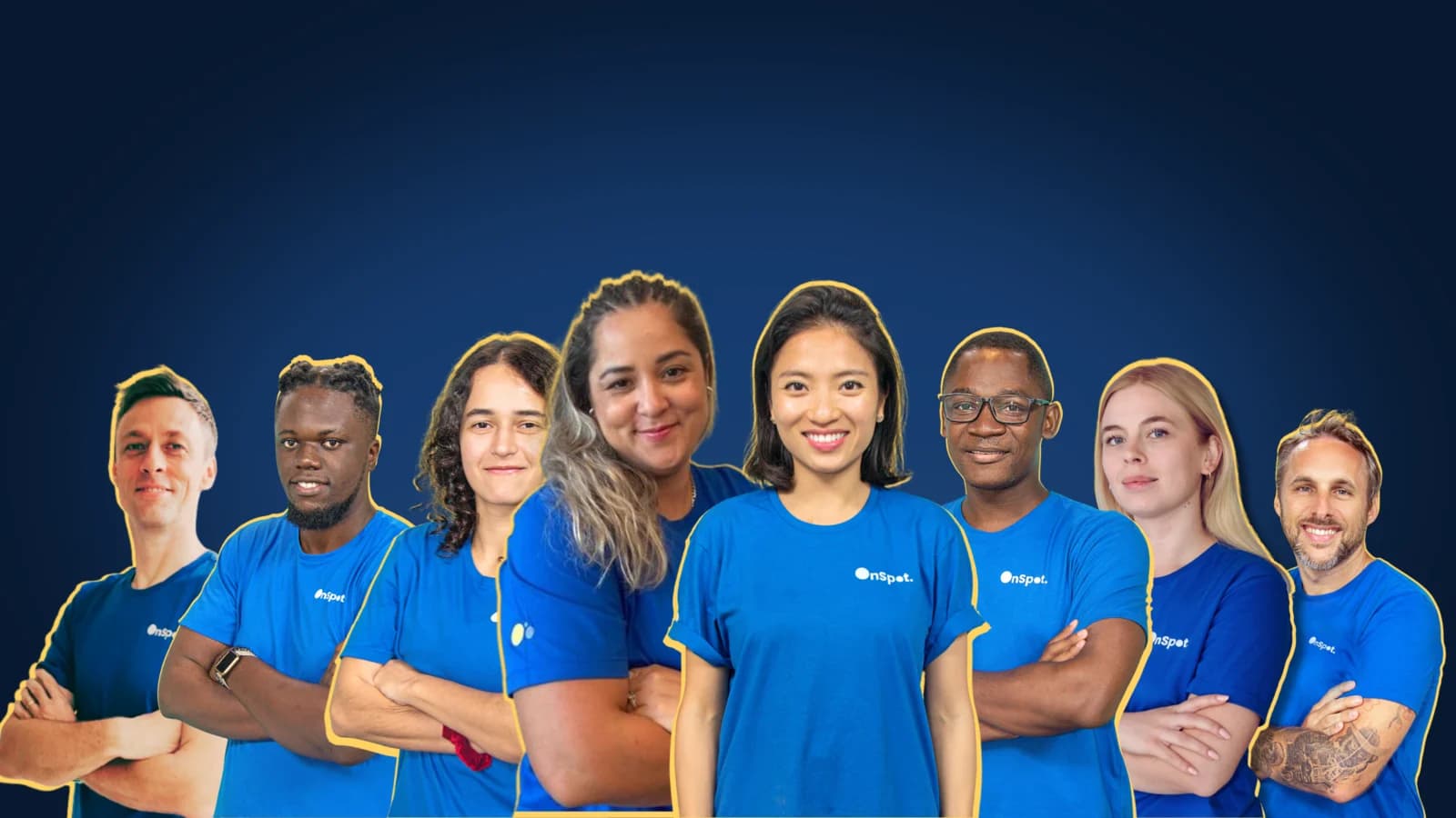 Group portrait of eight OnSpot team members in blue OnSpot T-shirts, smiling, most with arms crossed, on a navy background.